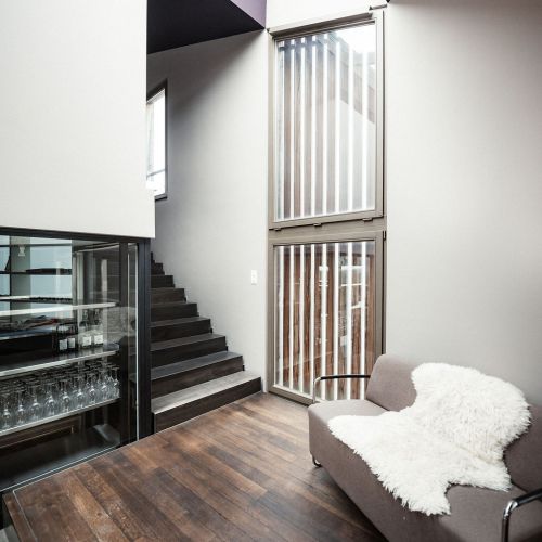 Farbgestaltung mit kt.color in einem Wohnzimmer mit Sofa und Treppenaufgang in Birmenstorf durch Meier Schmocker AG